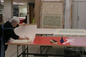 Figure 2 - Lining and drying William Morris wallpaper samples on karibari board. Photograph by Sophie Connor, November 2010