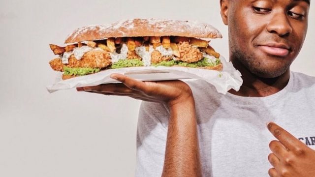 A man holding a very full sandwich