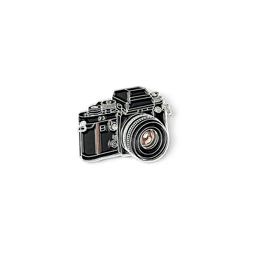 A vintage camera shaped pin badge.