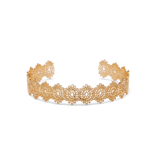 A gold cuff bracelet decorated with an ornate filigree pattern sits atop of a white surface.