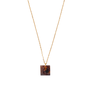 A square necklace pendant in a multicoloured marbled pattern hanging from a thin gold chain.