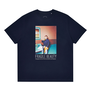 Blue t-shirt featuring a David LaChapelle portrait of Elton John sitting at a dining table with fried eggs behind his glasses.