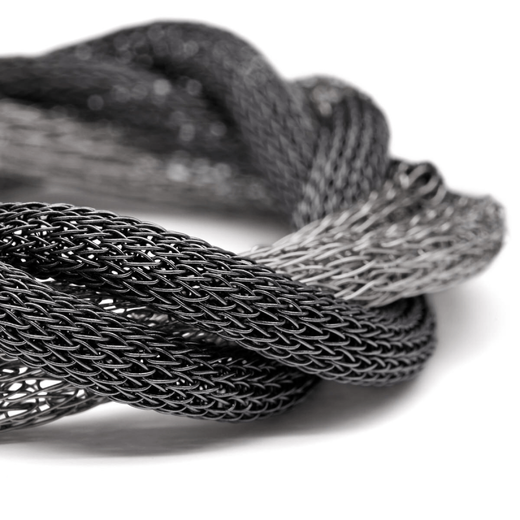 A close up of a silver mesh bracelet.