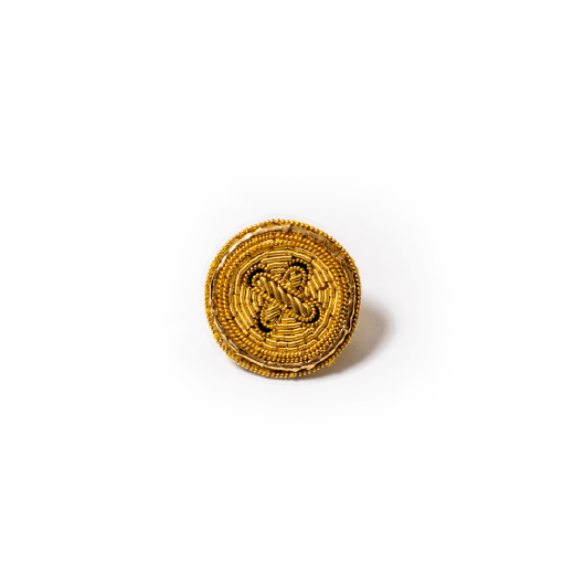 A brooch embroidered with gold thread in the shape of a round button.