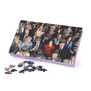 Jigsaw puzzle box featuring the photograph of a crowd of people. A few pieces of the puzzle are scattered next to the box.