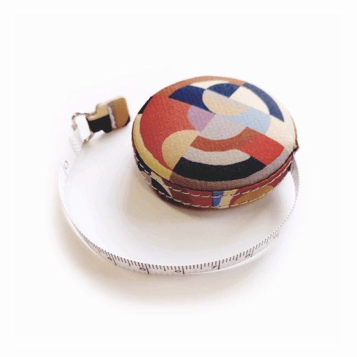 A round tape measure featuring a geometric art deco pattern.