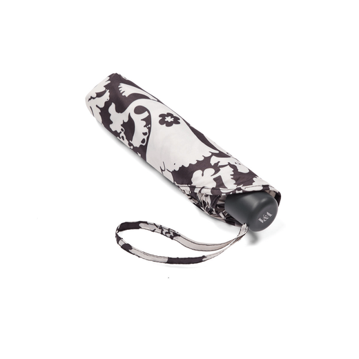 A closed pocket umbrella with a black and white floral pattern.