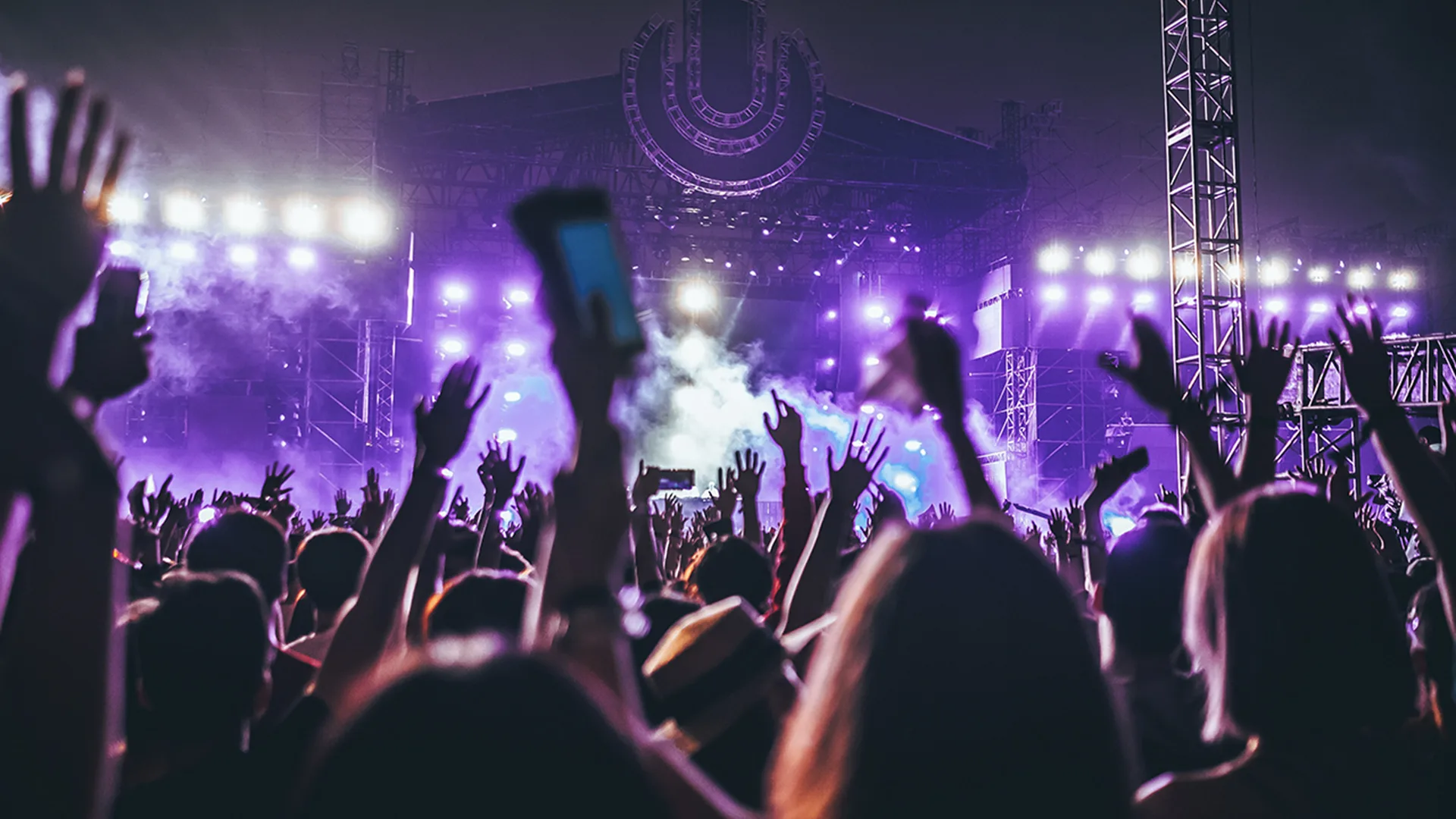 Large crowd with their hands in the air at a festival at night