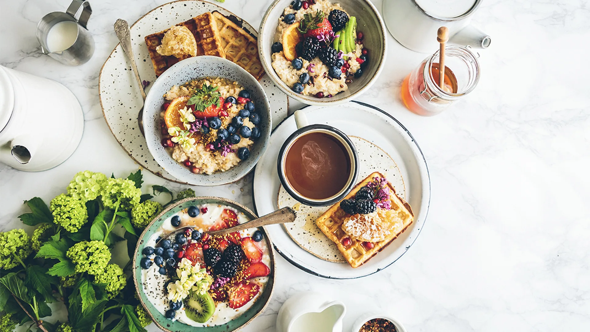 Breakfast with coffee, fruit, waffles and porridge.