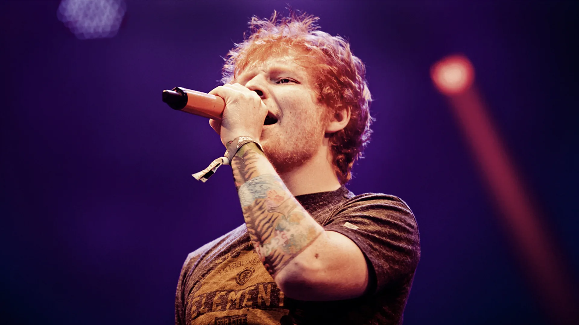 Ed Sheeran singing into a microphone