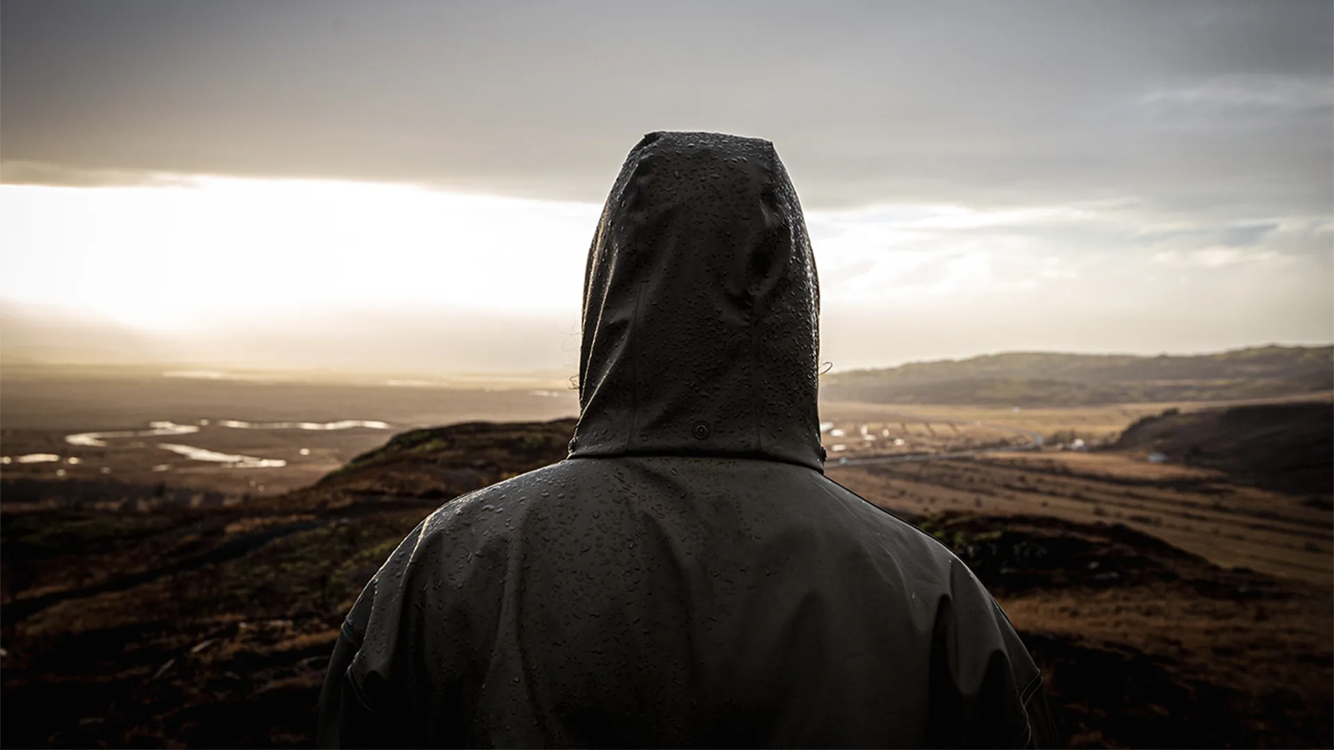 Hiker with hood up in mountains