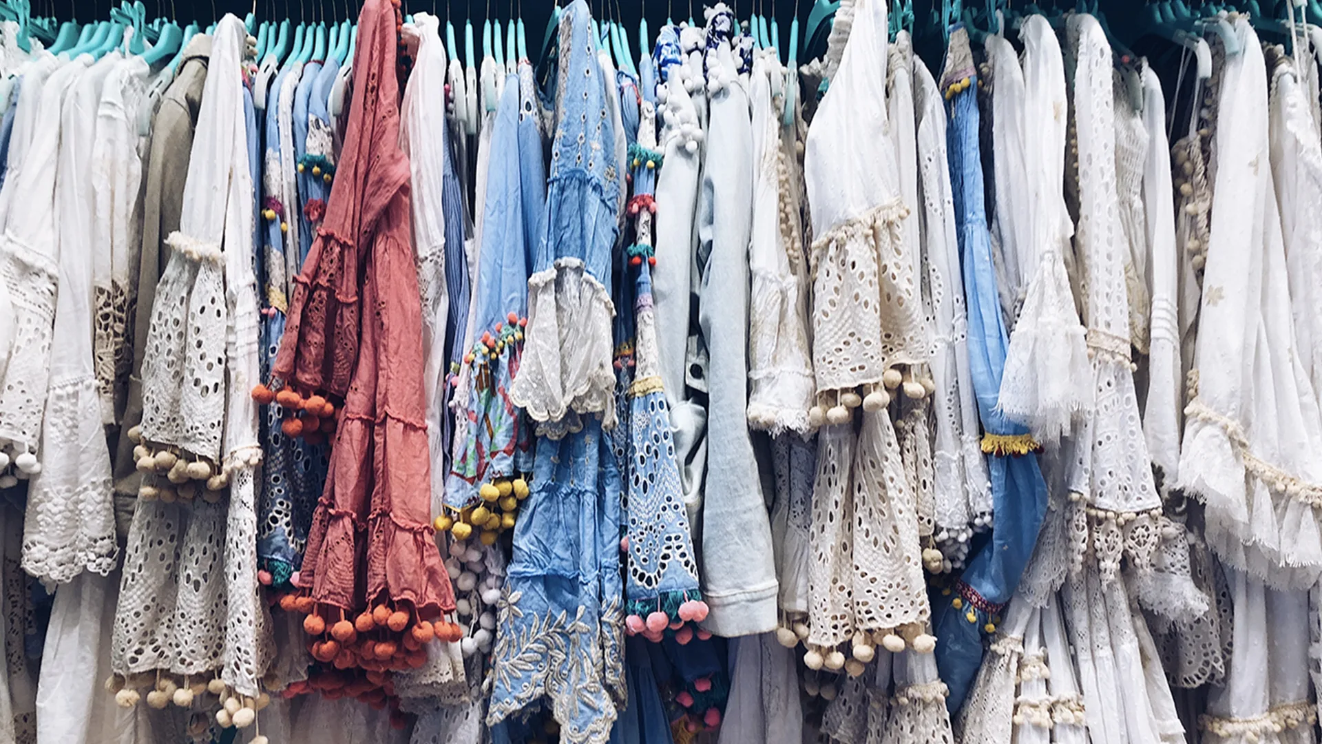 White and blue floral dresses hanging on a rail