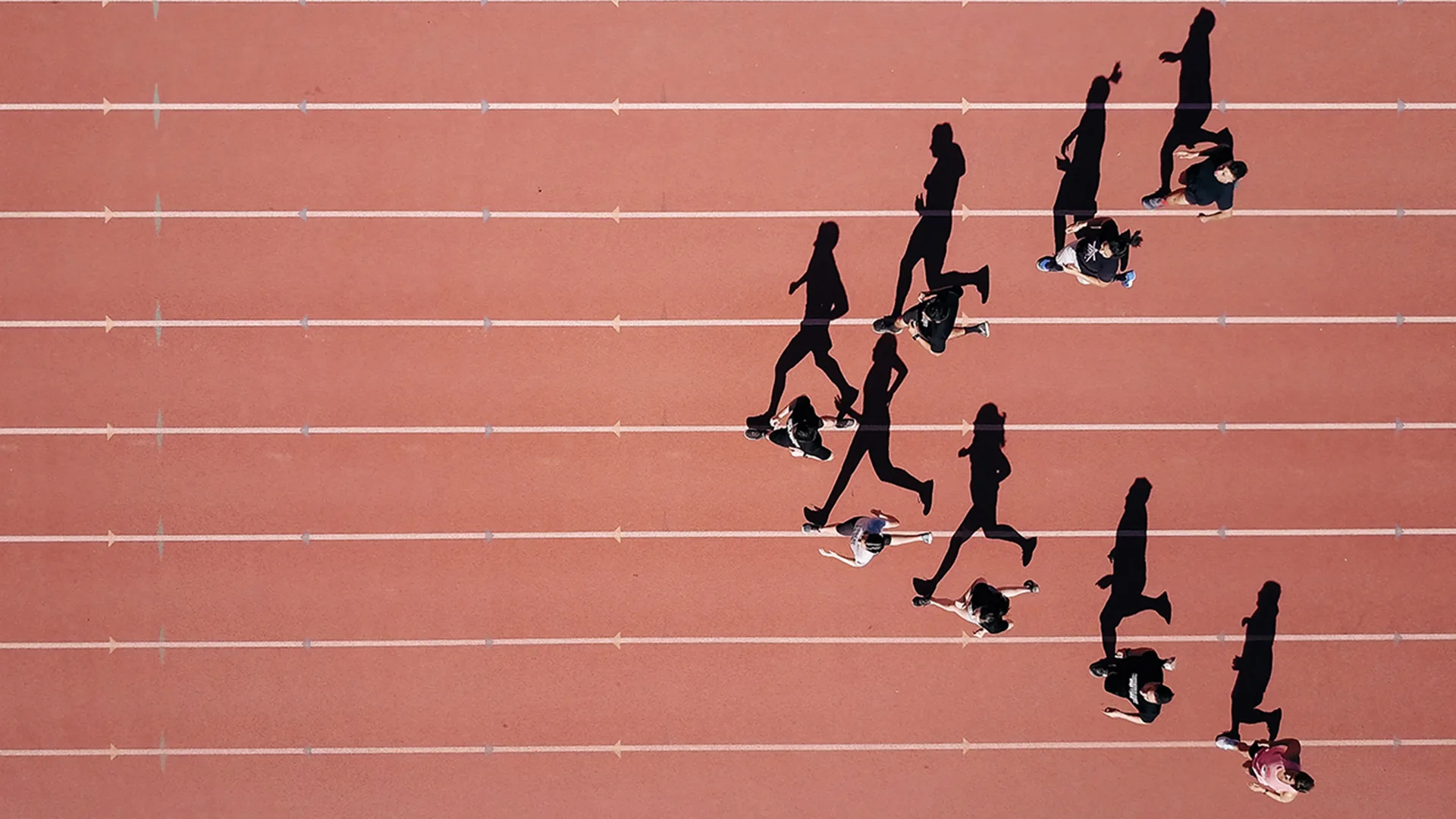 Eight people running along a race track