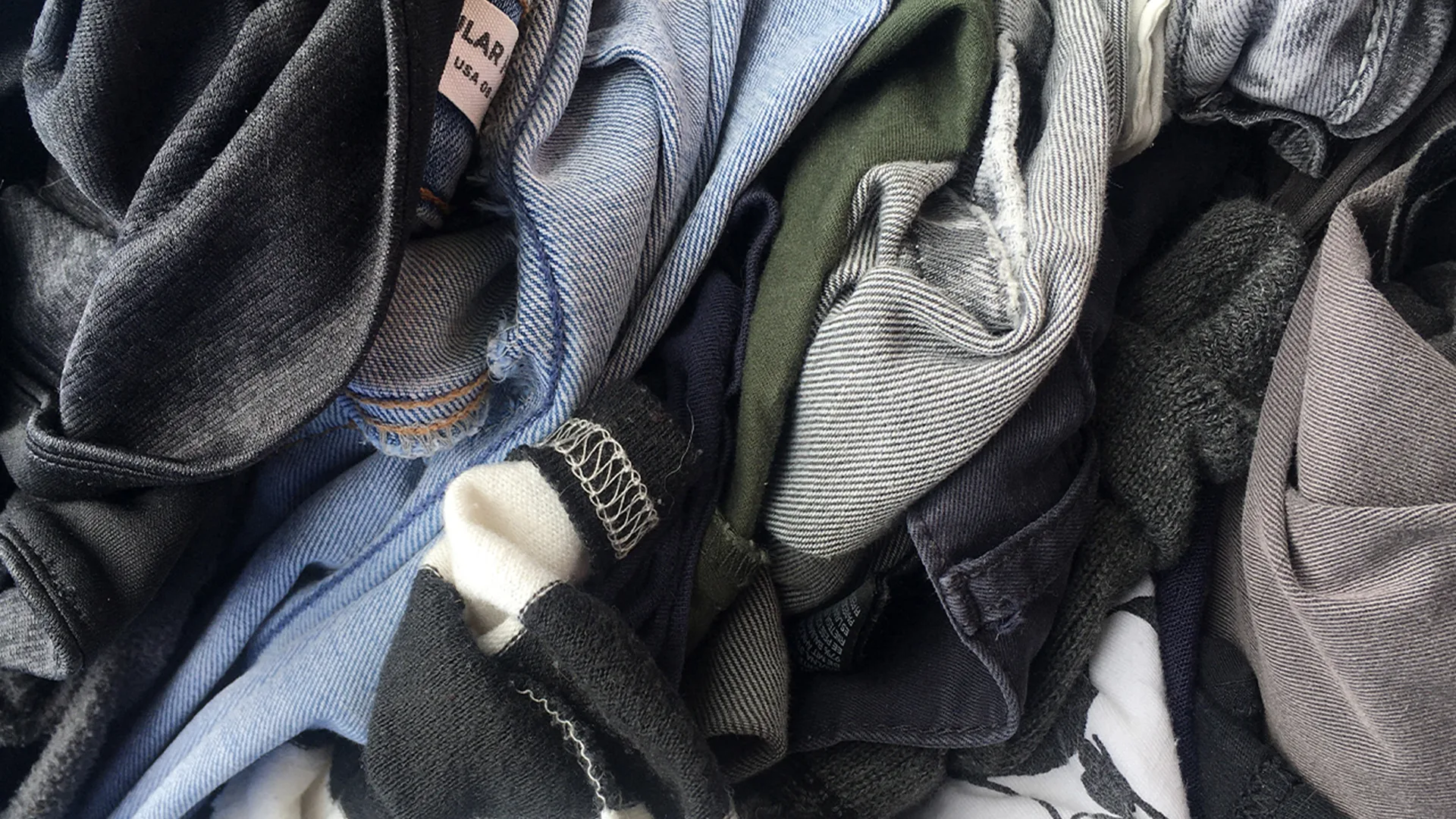 Close-up of pile of clothes made of different fabrics.