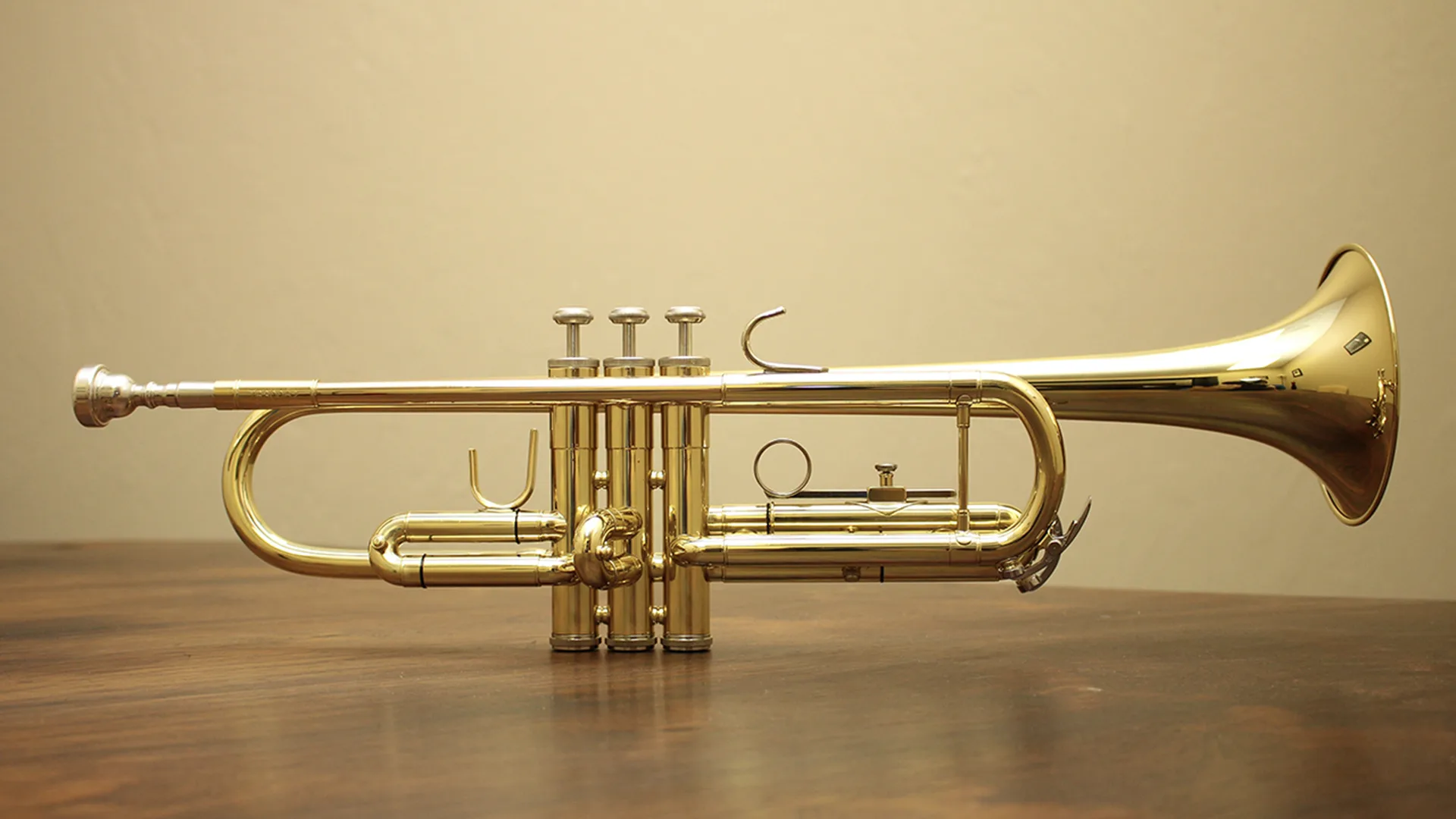 A gold trumpet on a wooden table