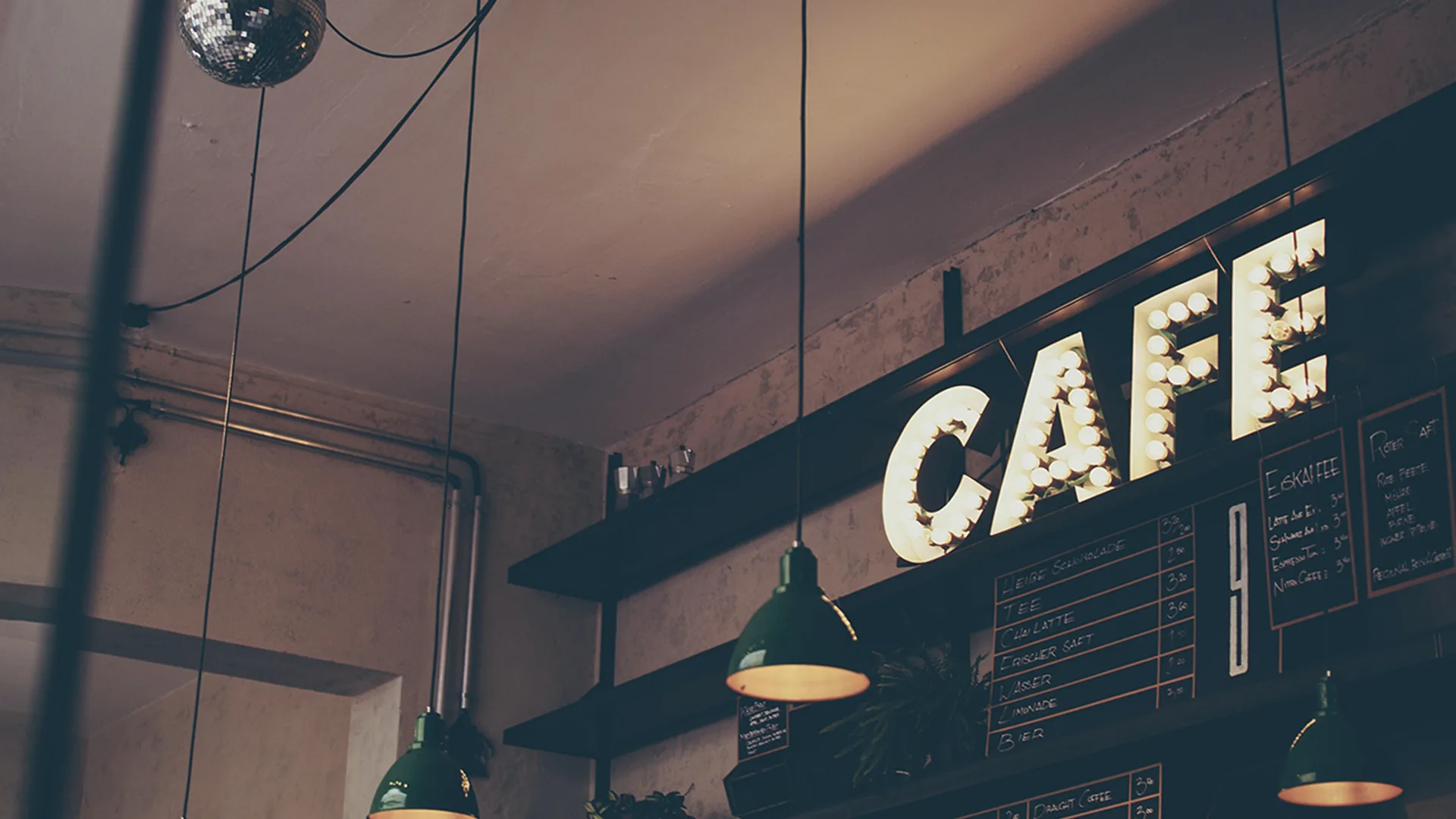 Wall inside a cafe with a big 'CAFE' light up sign.