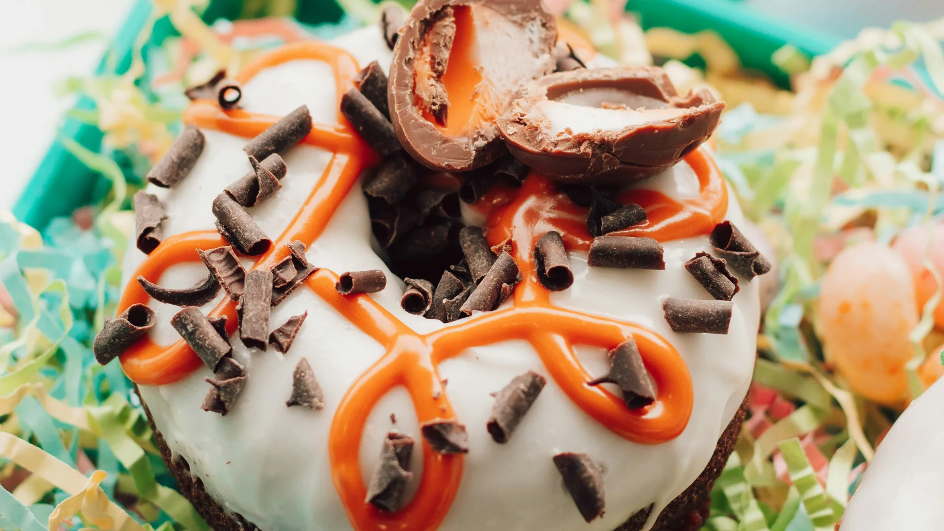 Close up of an Easter donut decorated with cadburys creme egg chocolate