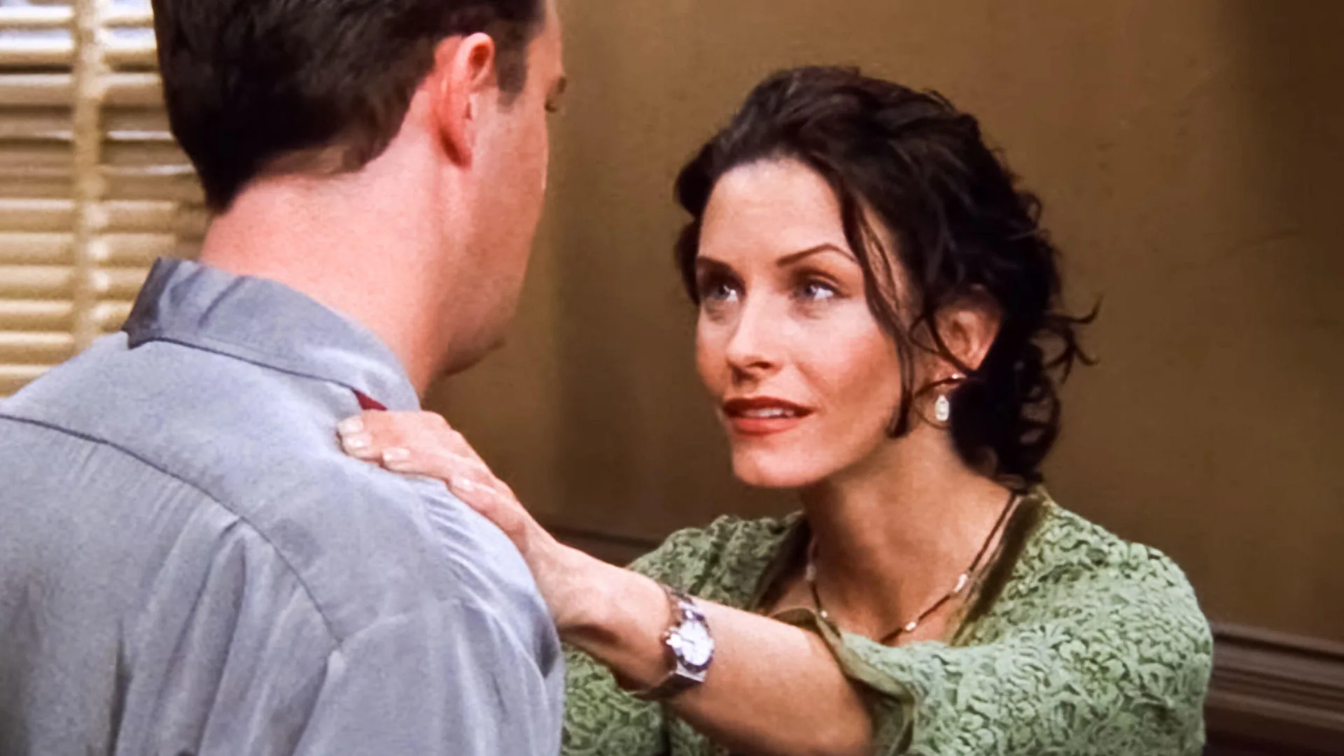 A photograph of the actress Courtney Cox who plays Monica on the show Friends holding onto Matthew Perry who plays Chandler.