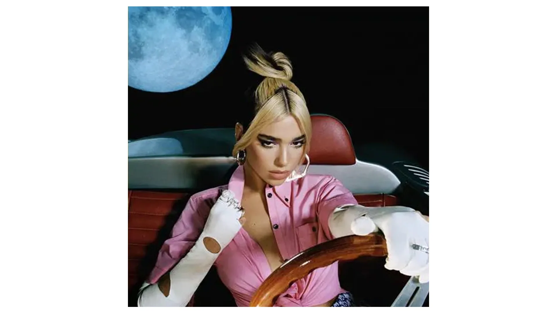 Dua Lipa's Future Nostalgia album cover depicts her in the driving seat of a vintage car wearing pink, against a black backdrop with a large full moon