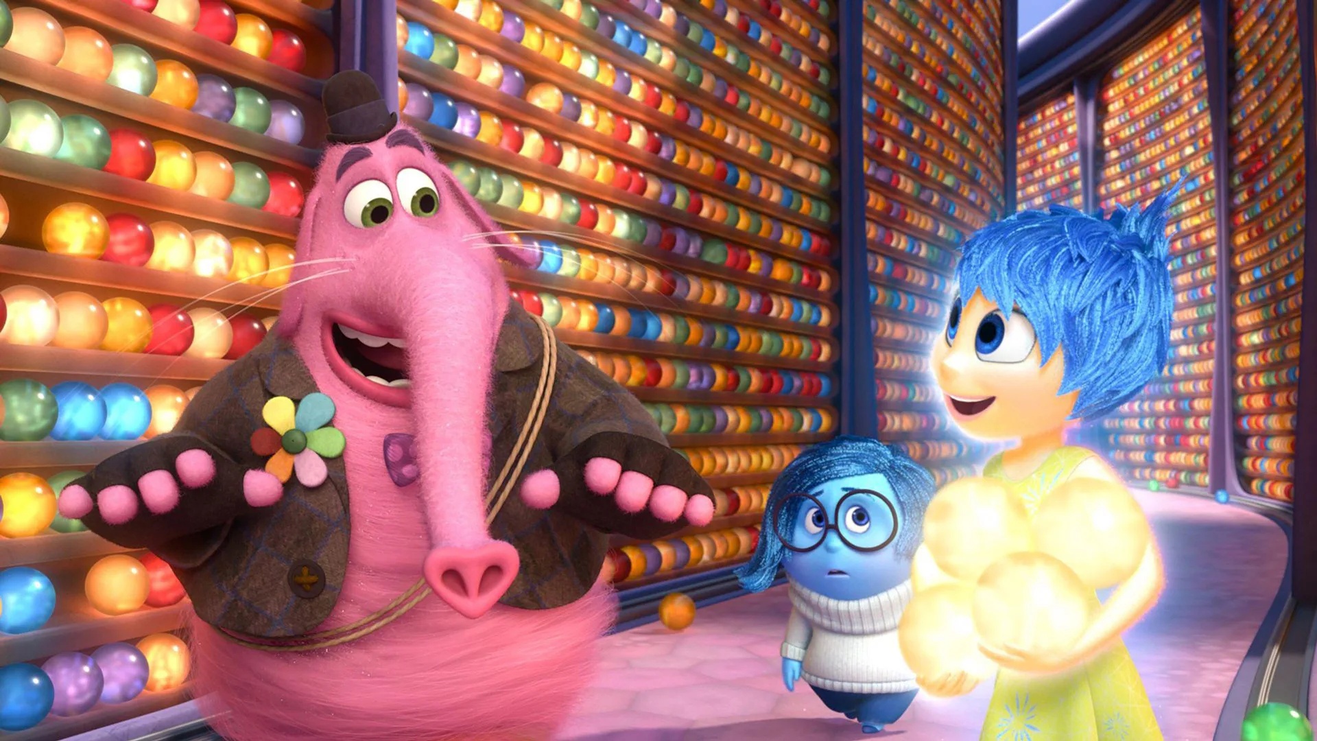A scene from Disney/Pixar's Inside Out showing Bing Bong and Joy walking with Sadness trailing behind. In the background are the memory balls on shelves.