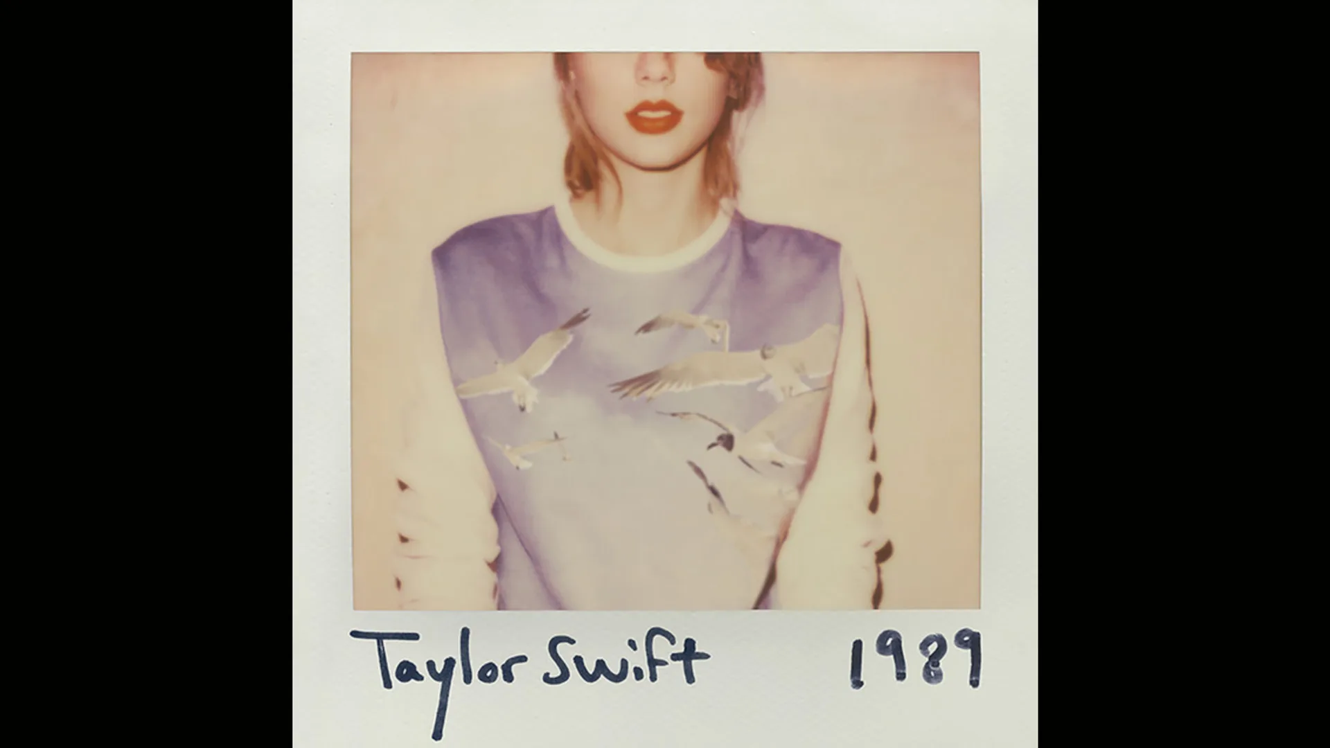 Taylor Swift's album cover for 1989 showing a polaroid image of the singer with her eyes cropped out of view, wearing a blue and white top with seagulls and the text TAYLOR SWIFT 1989 written in marker pen below.