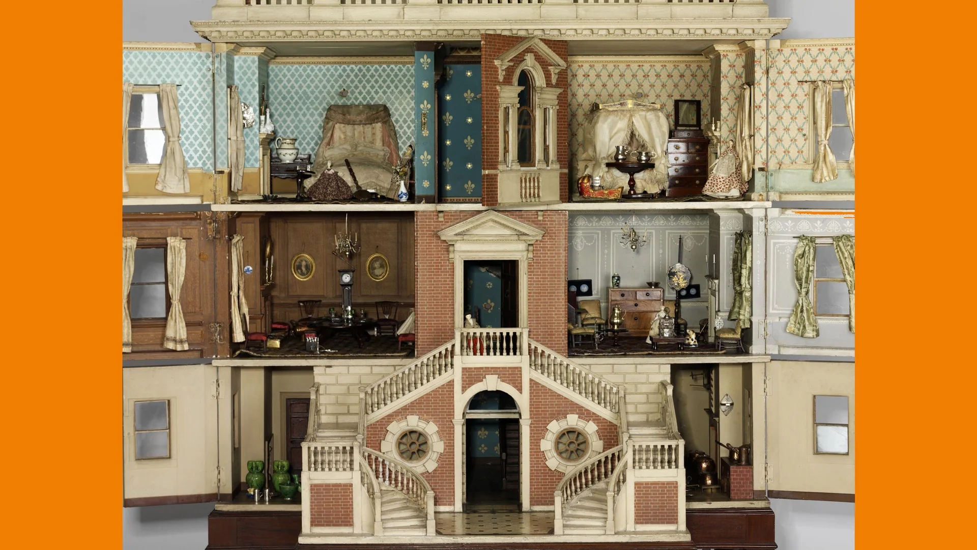 A photograph of the interior of an 18th century dolls house with many rooms and furniture all ornately decorated.