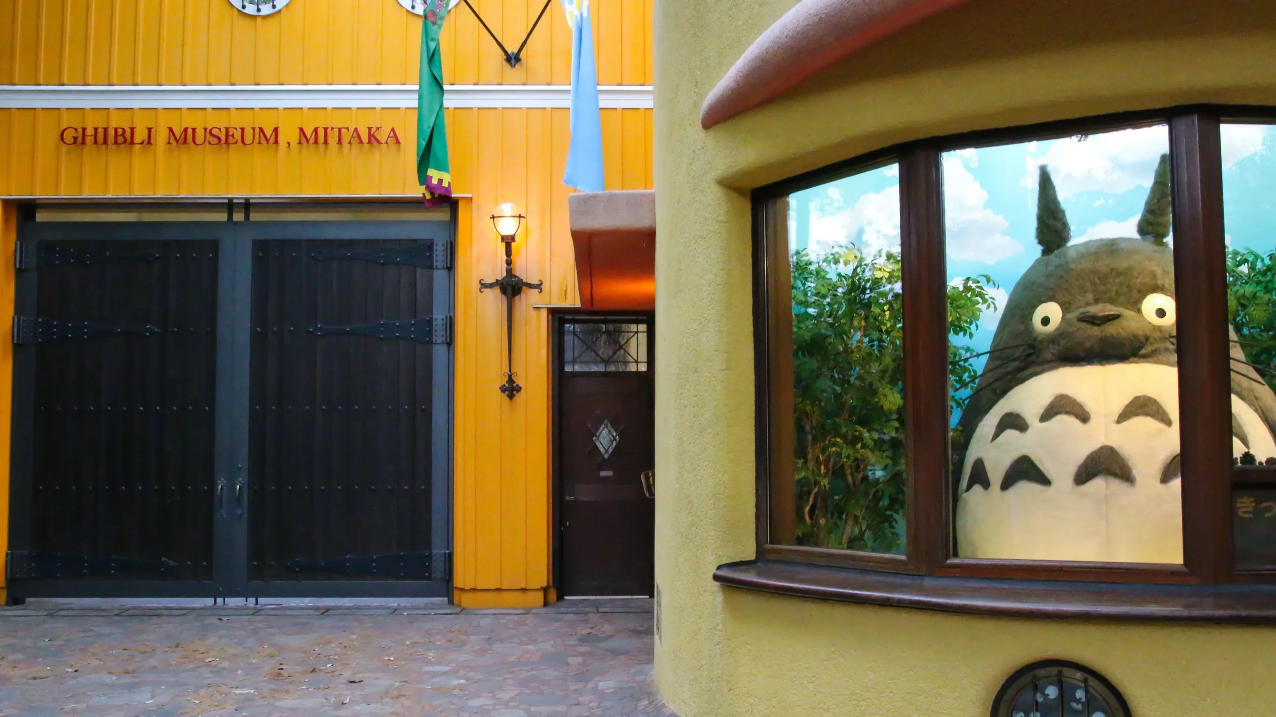 A large Totoro model peeks out of a window at Ghibli Museum Mitaka Entrance