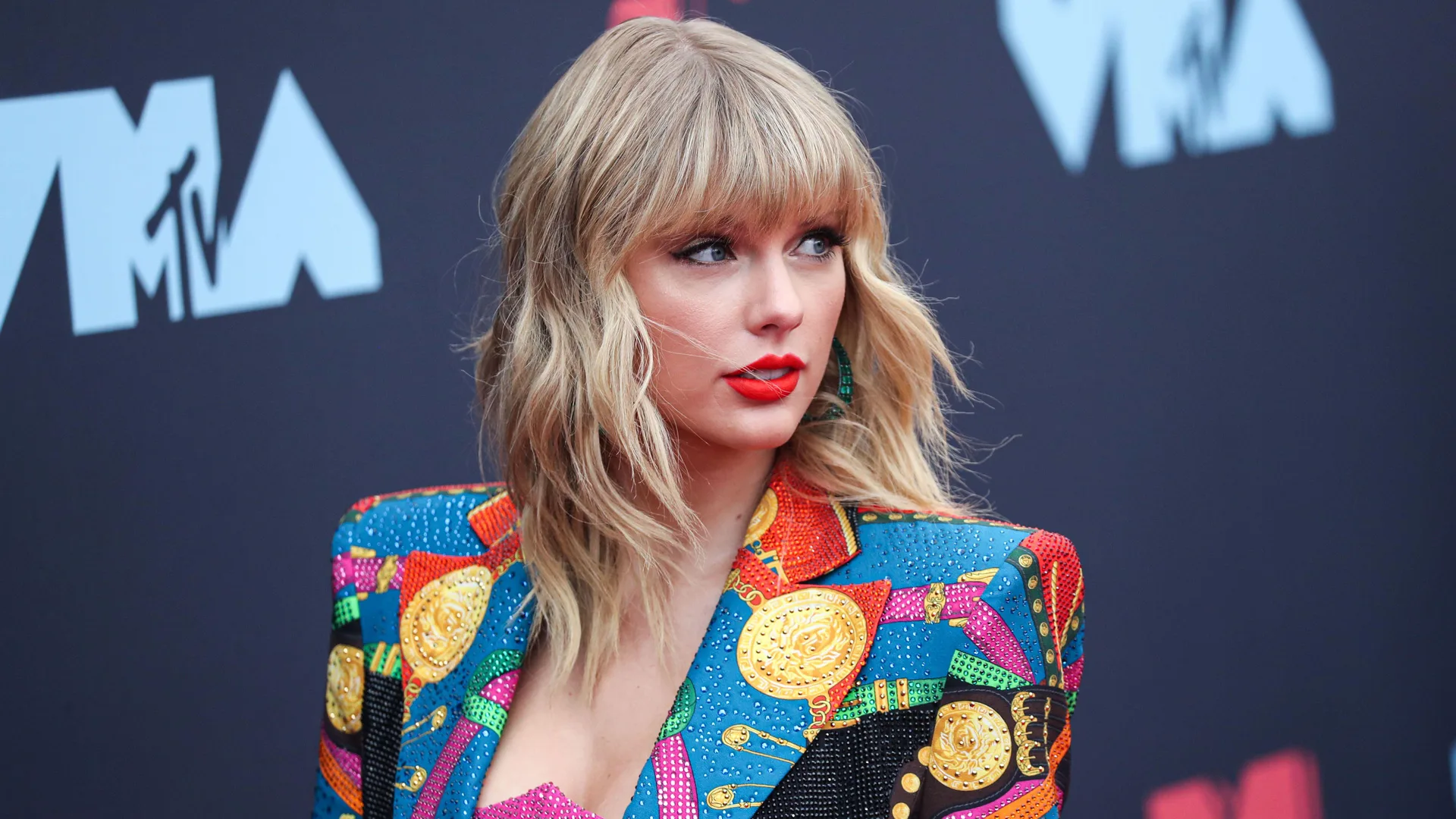 A photograph of Taylor Swift on the MTV Awards red carpet wearing a colourful jacket.