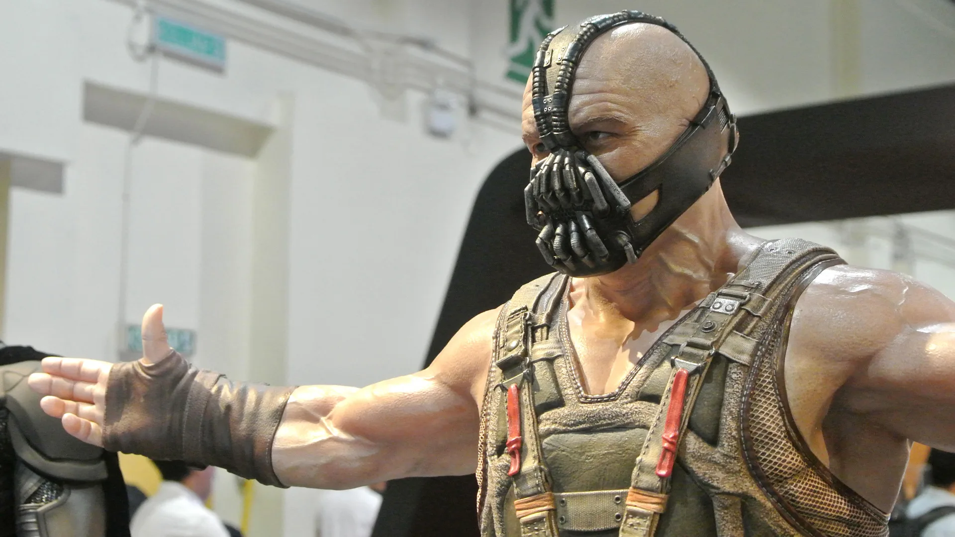 A photograph of Bane from Batman holding his arms outstretched against a building background