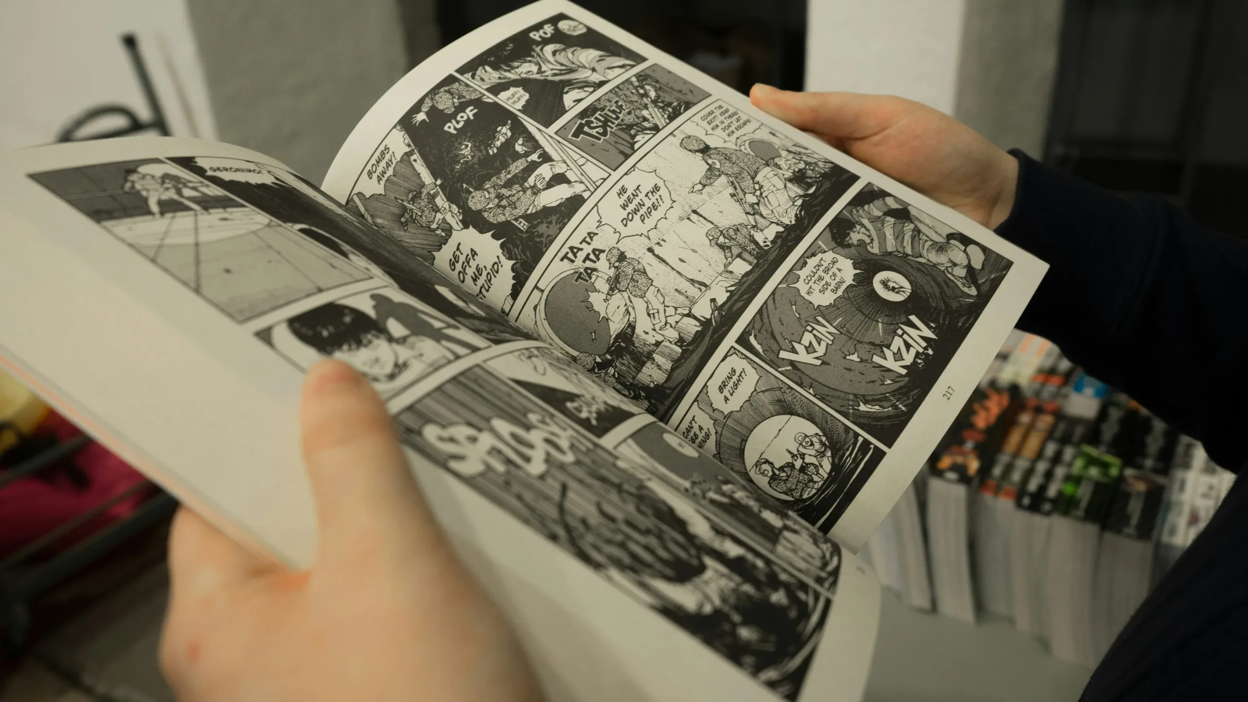 person holding an opened graphic novel book