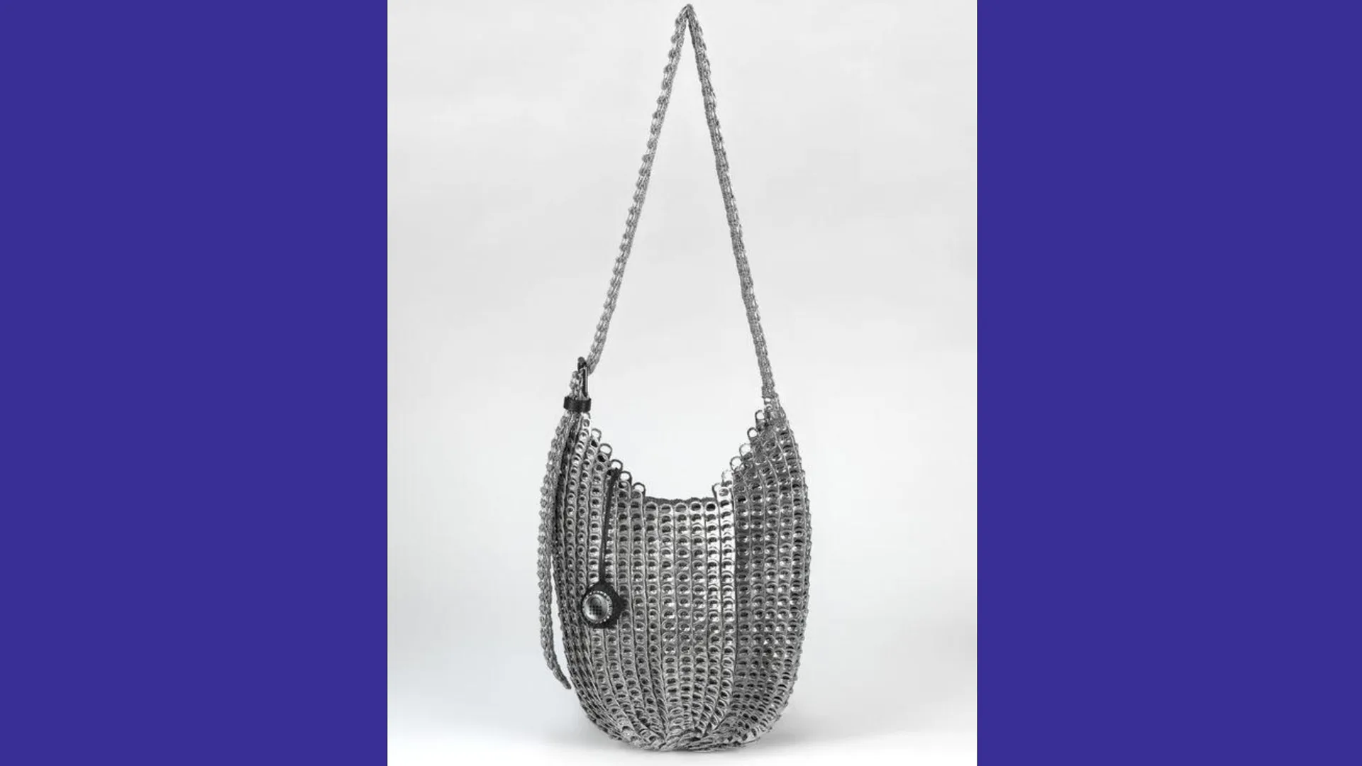 A photograph of a handbag made out of recycled ring pulls against a white background with blue borders