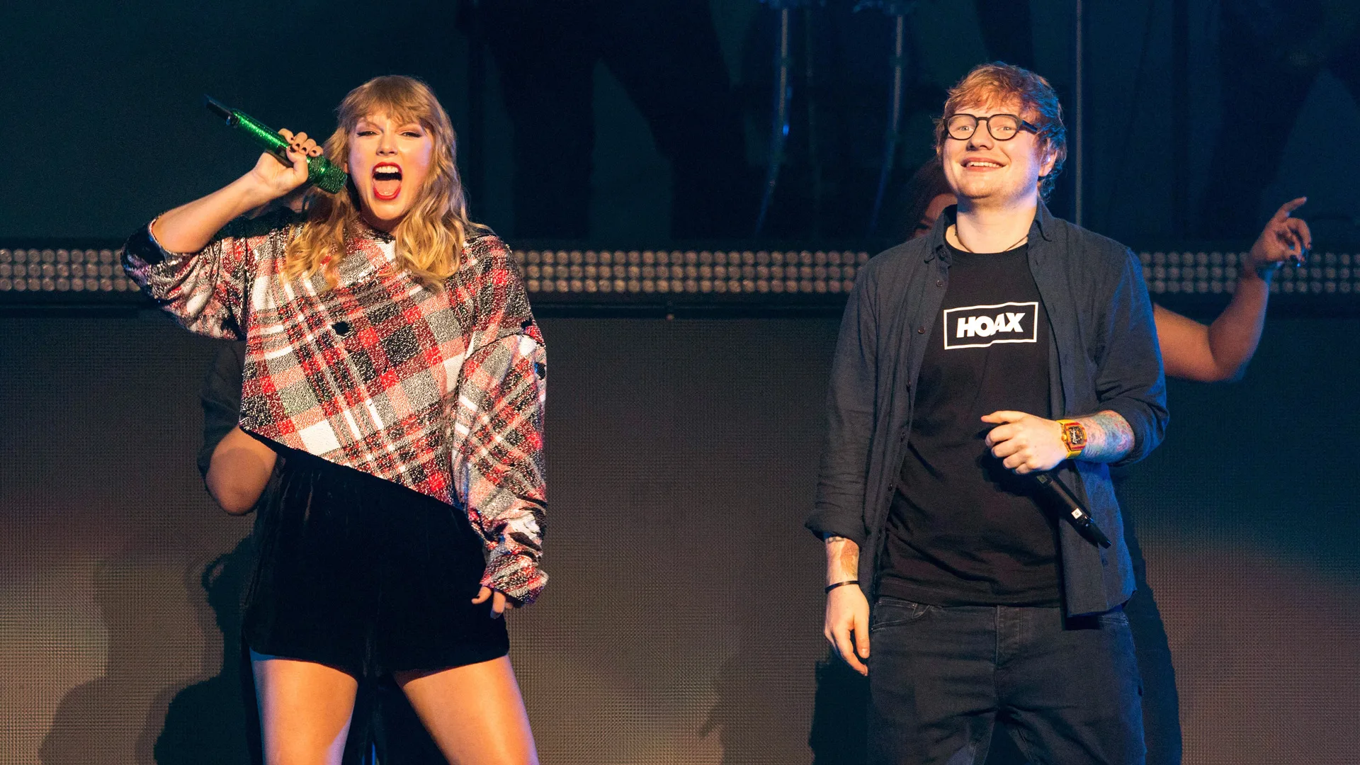 A photograph of Taylor Swift and Ed Sheeran performing on stage together