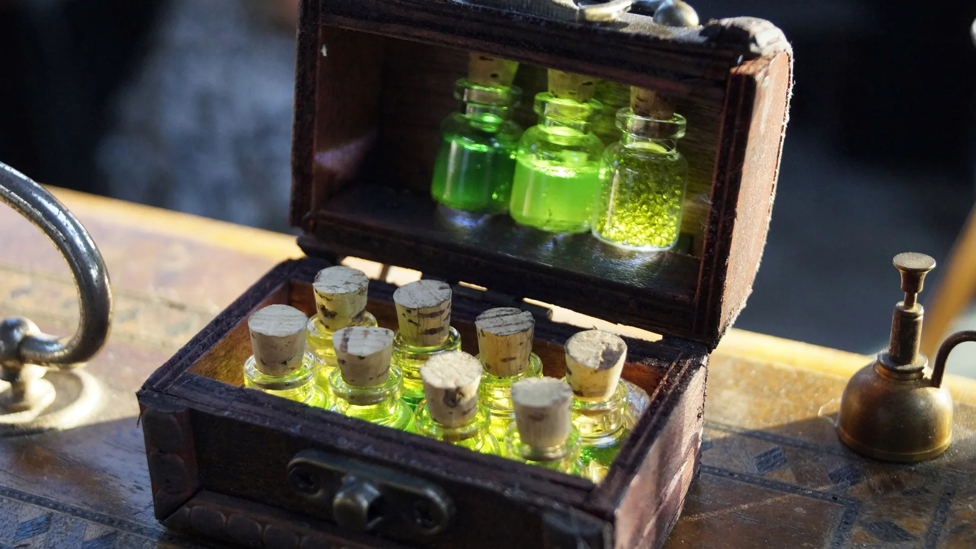 A photo of some green potion bottles in a little wooden chest sat on a table