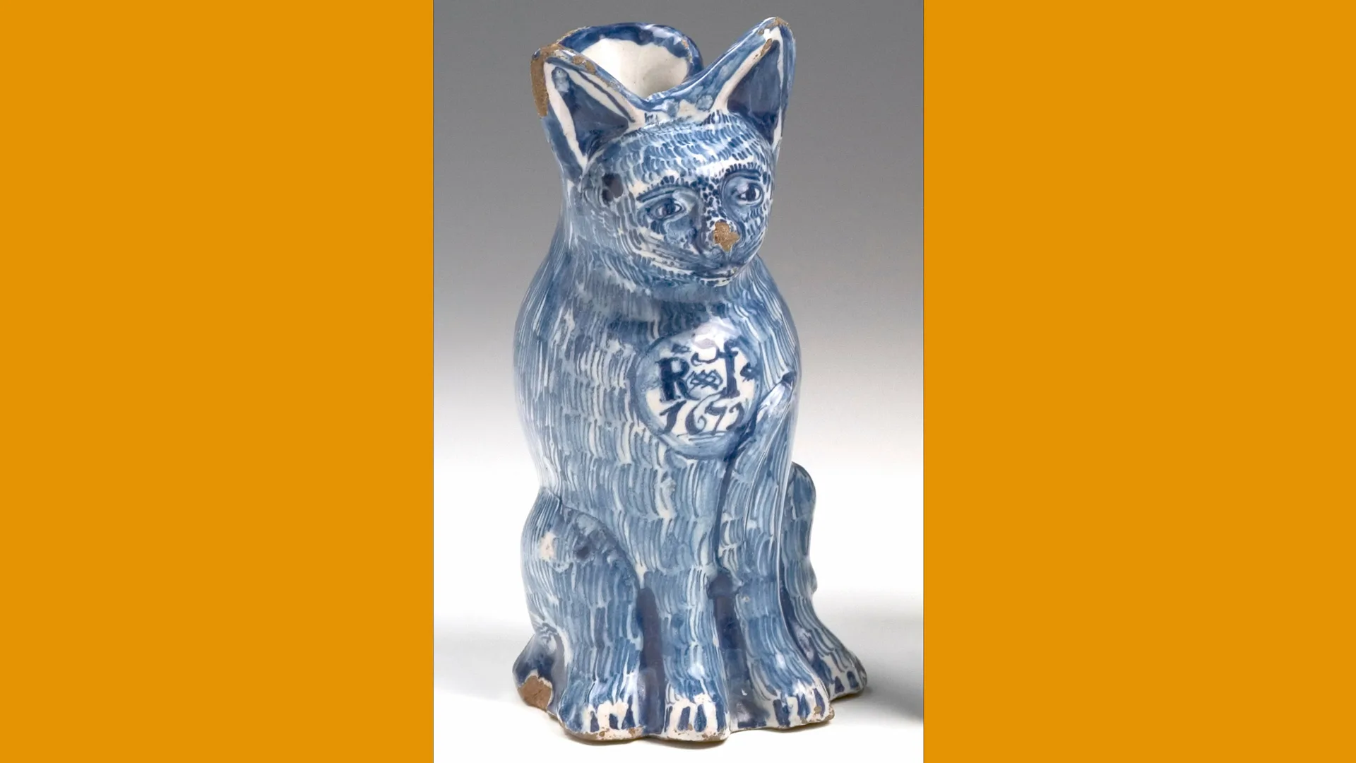 A photo of a blue and white ceramic jug shaped like a cat, collected by Henry Willett