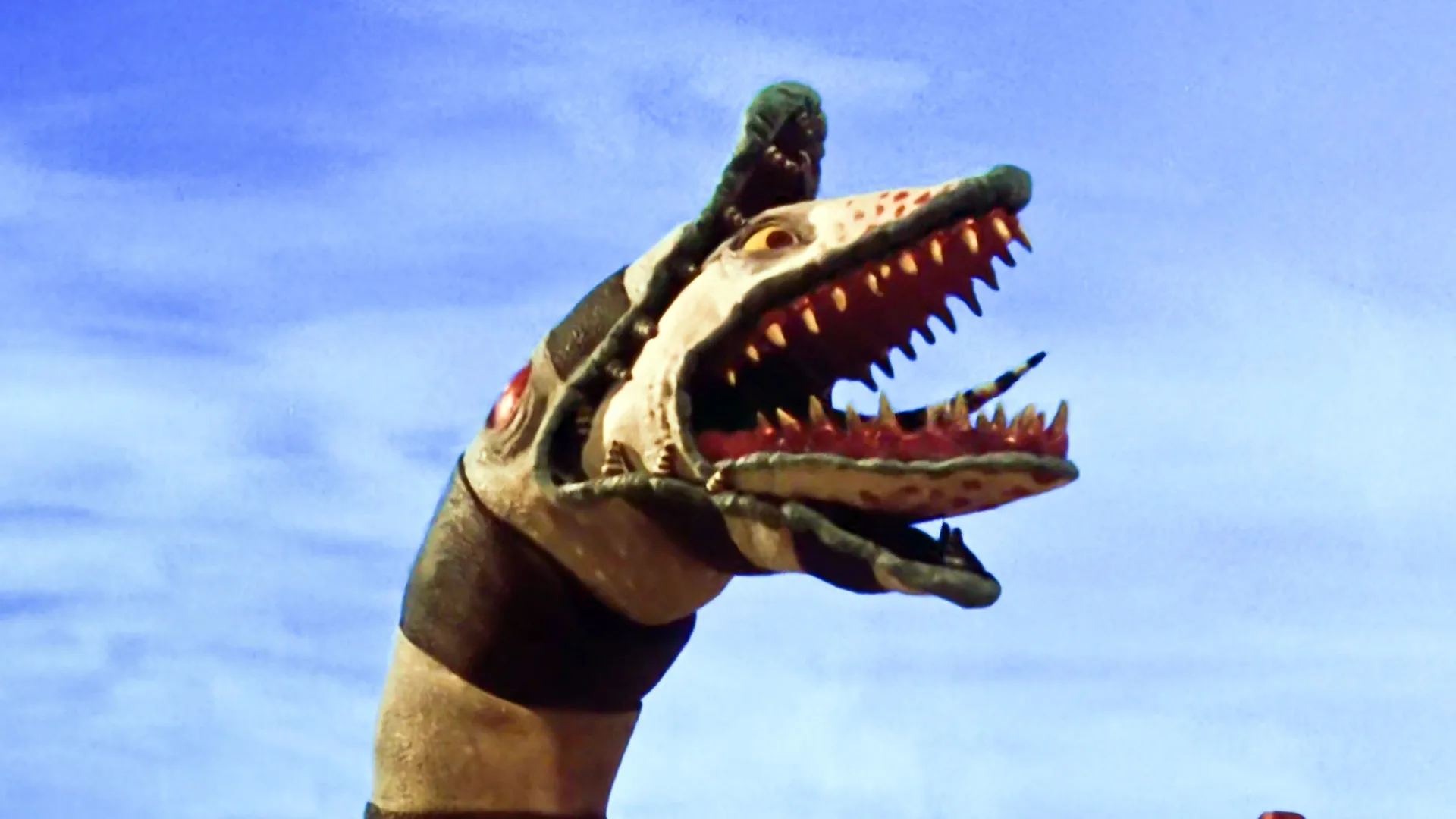 A still from the movie Beetlejuice showing the stop motion sandworm creature with its mouth open showing sharp teeth and a tongue