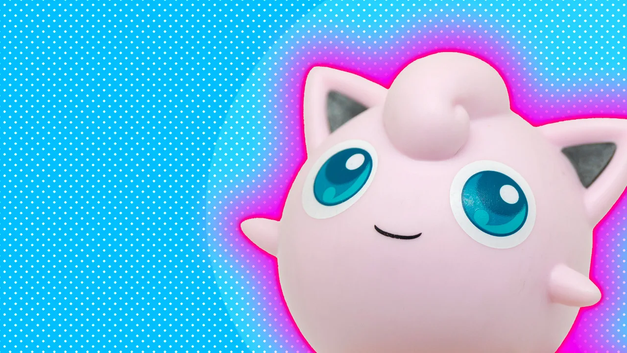 A photo of a Jigglypuff Pokemon figurine smiling against a blue dotted background with a pink halo