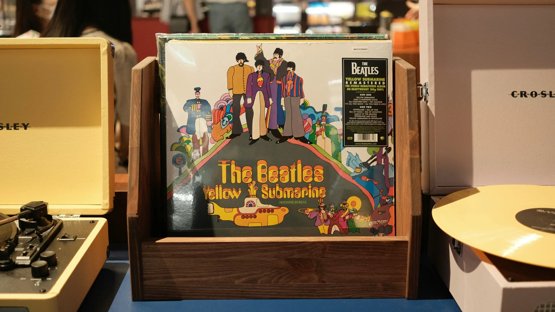 A photo of the Beatles album Yellow Submarine on vinyl stood between two vinyl players