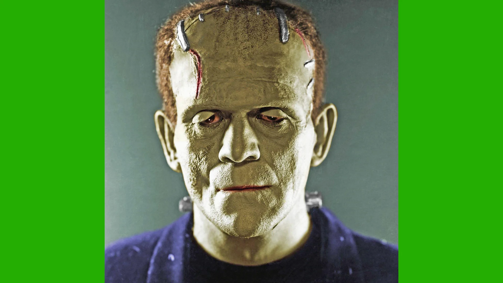 A photo of Boris Karloff as the Monster in Frankenstein. The photo is colourised in greens and purples showing a close up of his makeup. He is against a blue grey background with green borders.