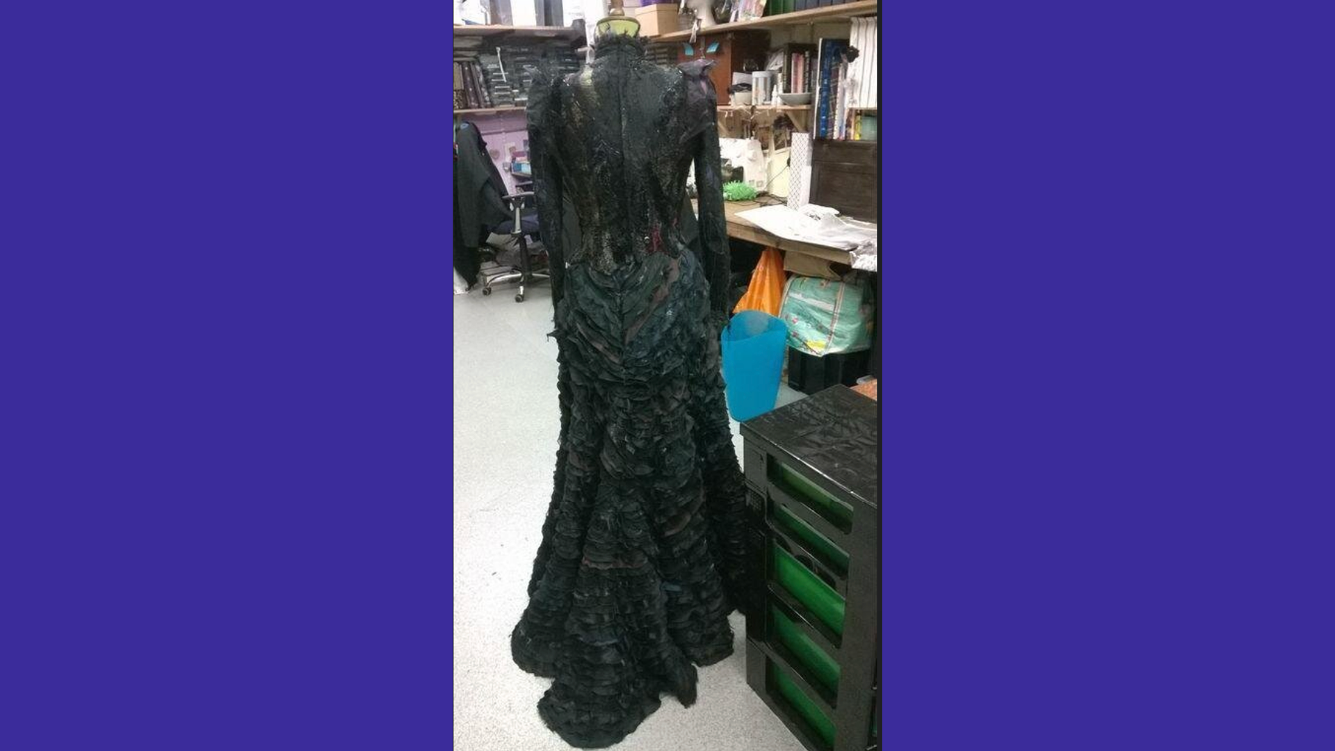 A photo the Elphaba costume from Wicked designed by Susan Hilferty - it shows the back of the costume with the waterfall train and many black layers.