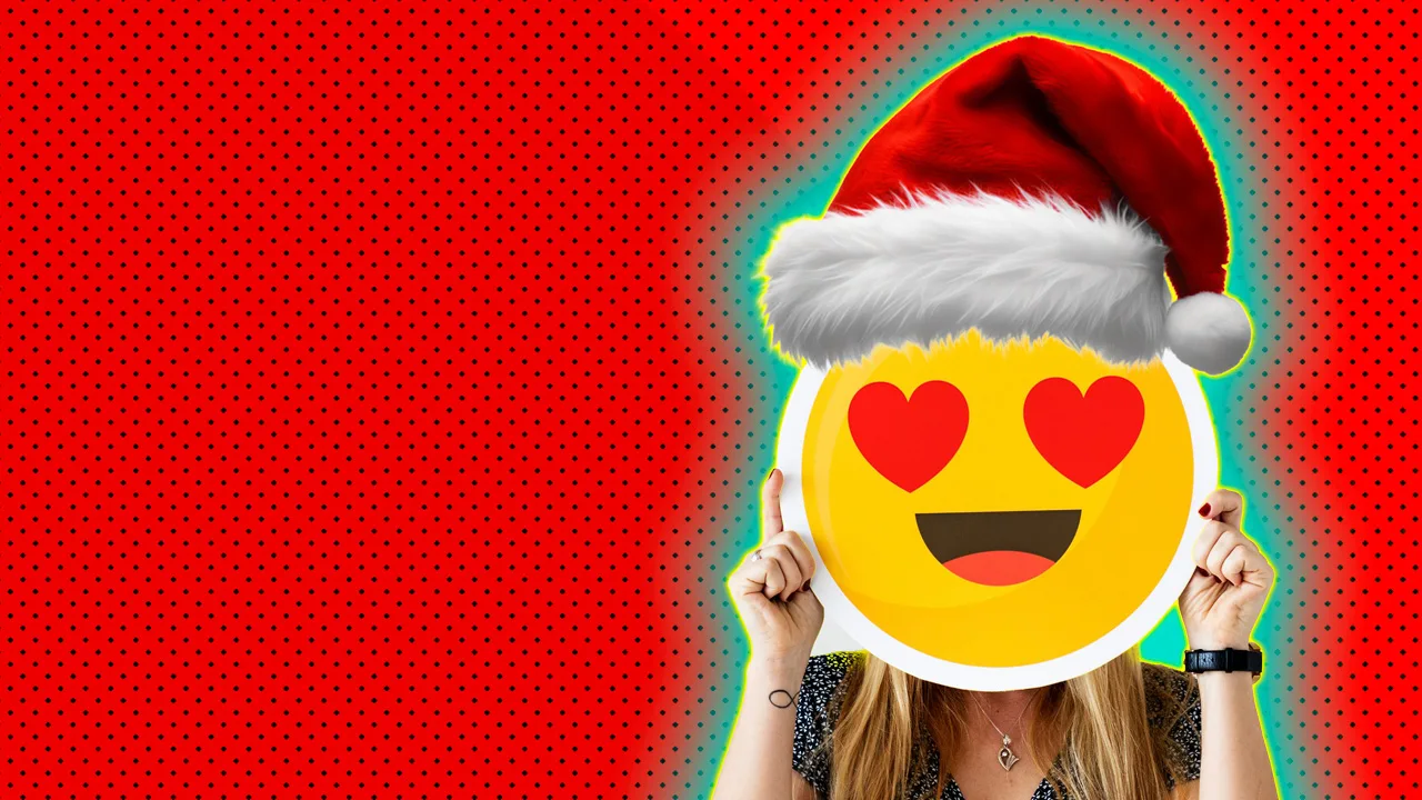 An image showing a woman holding an emoji face with heart eyes and a santa hat against a red dotted background with green halo.