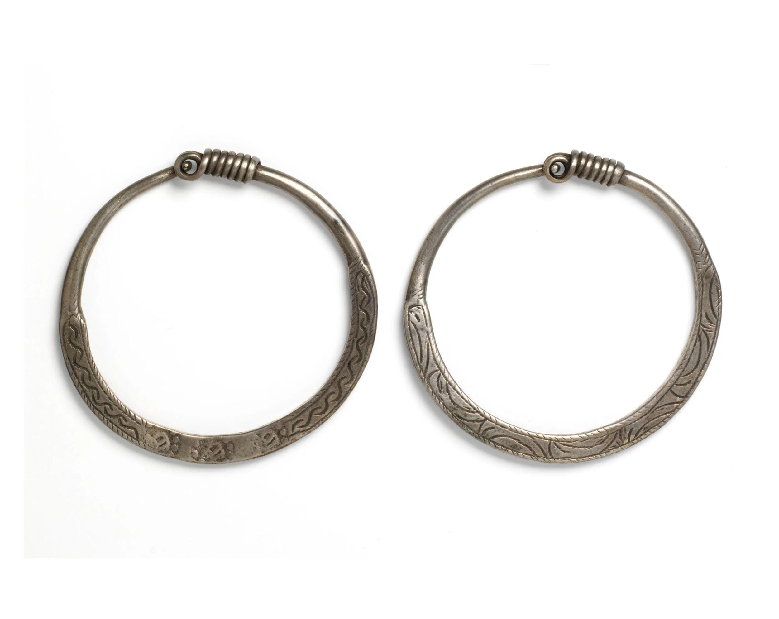 A pair of silver hooped earrings against a white background.