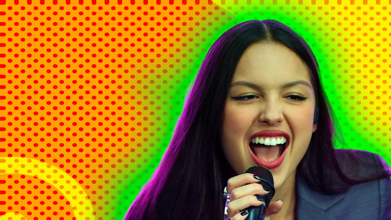 A photo of Olivia Rodrigo singing into a mic with a green halo around her against a yellow and orange dotted circular background.