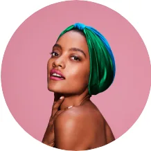 A young woman wearing a blue and green silk head wrap.