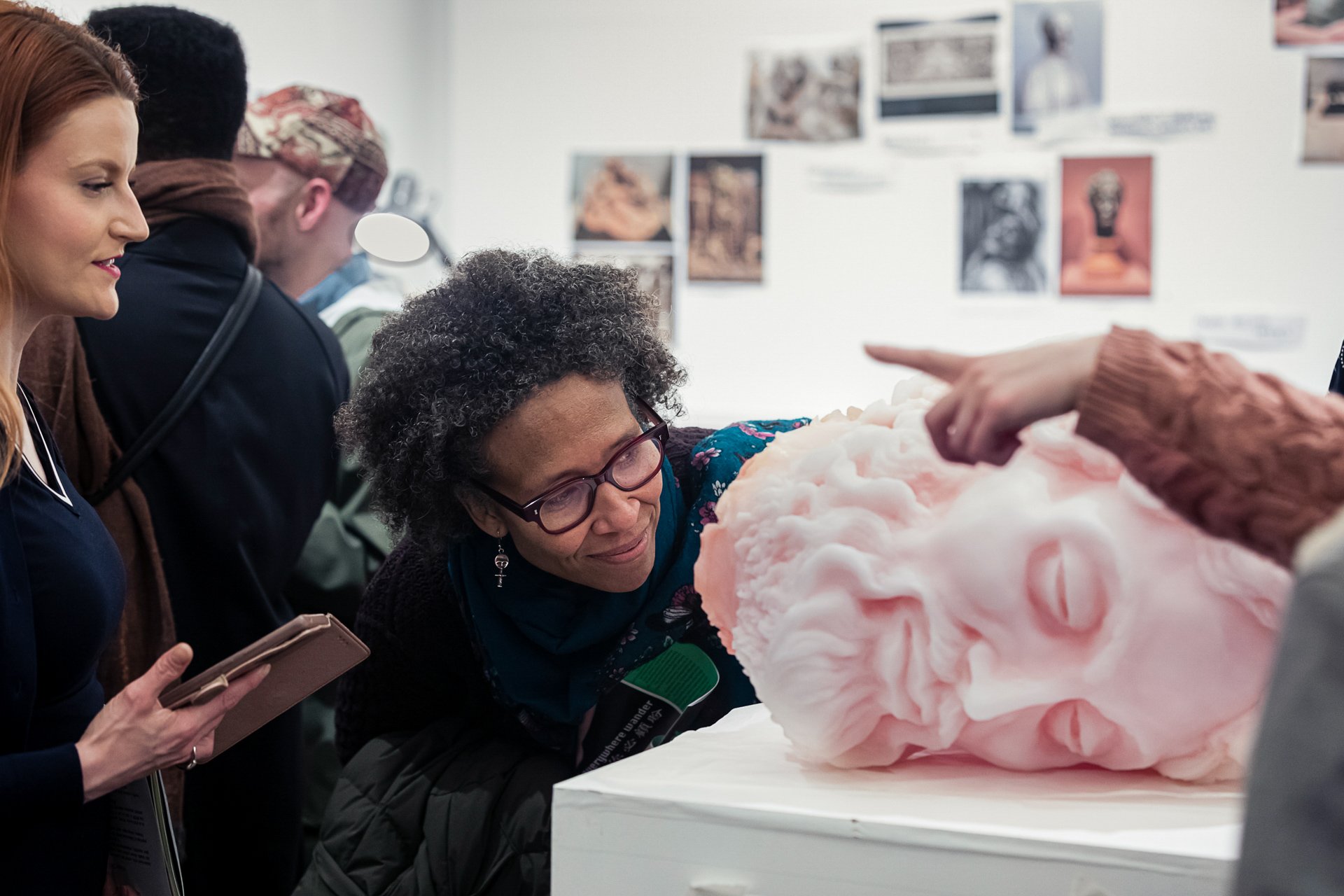 a Member examines a pink bust in a Members' exhibition preview