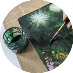 A close up of a painting on paper, a paint brush and a jar filled with green colour paint. 