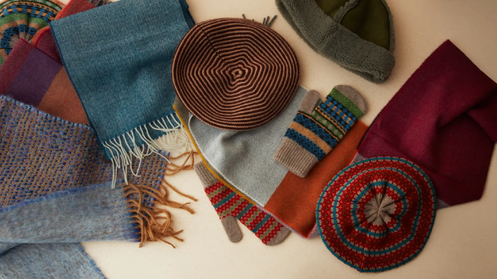 Winter accessories in a variety of styles, colours and materials; including a sky blue mohair scarf, mulberry cashmere beret and woolly fairisle patterned mittens